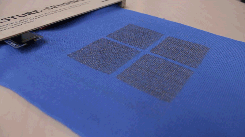 Animated gif on loop showing a hand touching the fabric clockwise and counter clockwise. On the left there is a small screen showing different animations according to the direction in which the fabric was being touched.