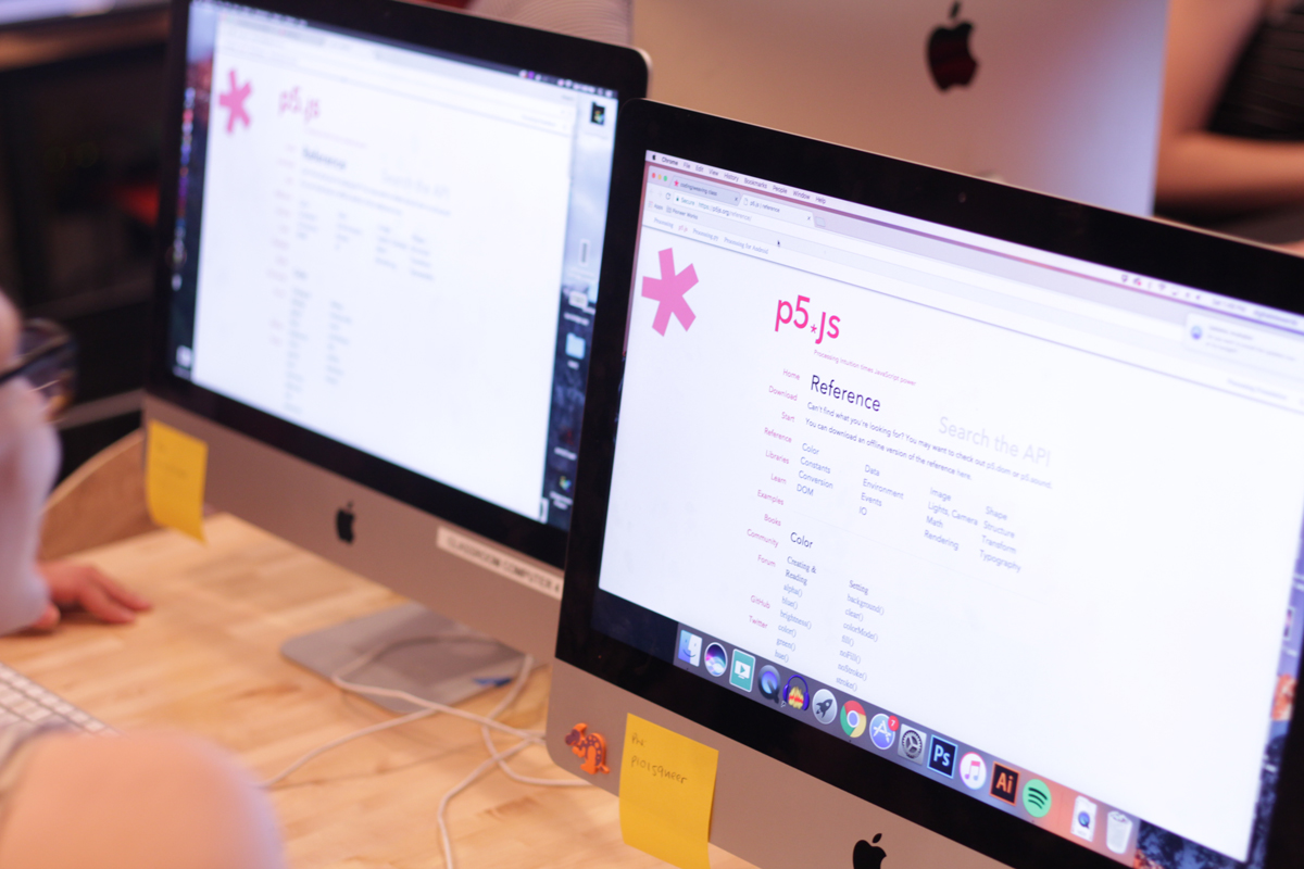 Photo of two computers showing the p5.js website.